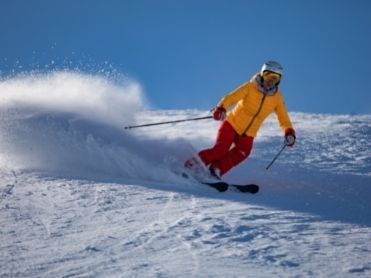 Skifahrer auf der Piste gelben Jacke